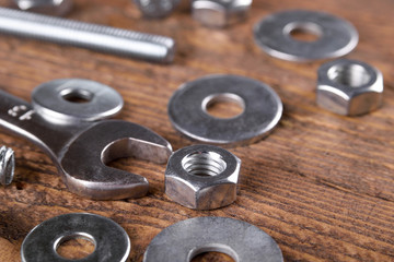 Keys wrenches, bolts, nuts, washers on a wooden background