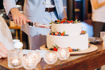 man slices festive fruit cake knife cream