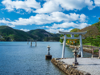 秋晴れの青空と海へと続く鳥居を持つ和多都美神社の風景　10月