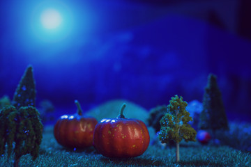Halloween pumpkins and dark forest in the moonlight Halloween background. Fairy tale. Macro. Artificial magic dreamy world.