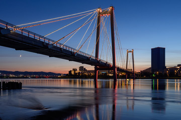 Fototapeta na wymiar Krasnoyarsk night city view illuminated pedestrian bridge