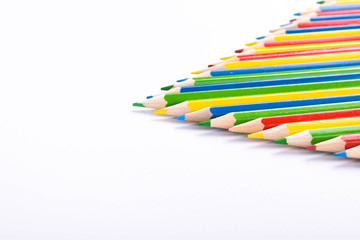 Fototapeta premium Many different colored pencils on a white background with a place for text and cory space .
