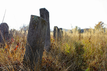 An old cluttered Jewish cemetery with uneven tombstones carved in Hebrew is a preserved story.