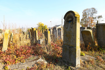 An old cluttered Jewish cemetery with uneven tombstones carved in Hebrew is a preserved story.