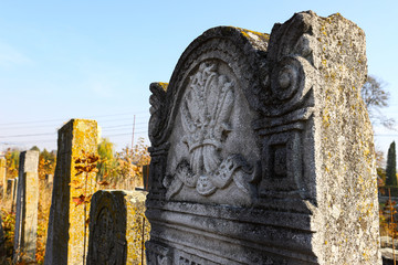 An old cluttered Jewish cemetery with uneven tombstones carved in Hebrew is a preserved story.