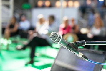  Microphone in focus against blurred people at business presentation