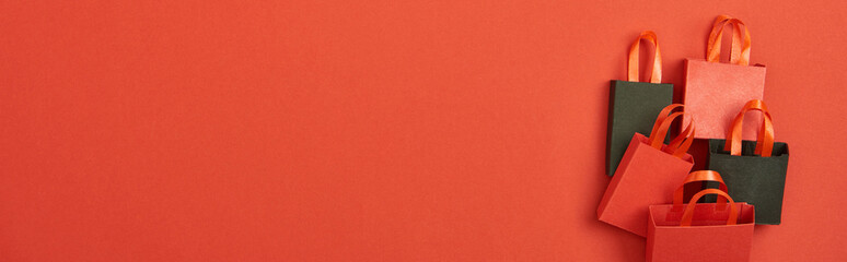 top view of shopping bags on red background with copy space, panoramic shot