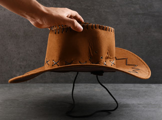 A male hand holding cowboy hat