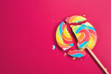Swirl round broken lollipop on pink background. concept of unhealthy food,sweets and candy day