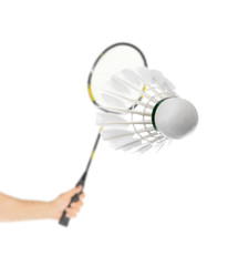 Hand with badminton racket and feather shuttlecock