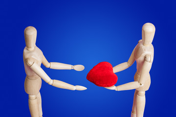 Wooden toy figures with heart on blue