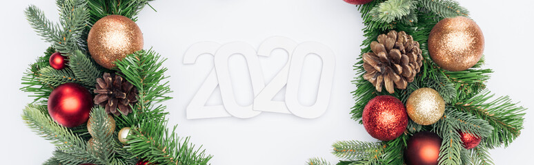top view of 2020 numbers in Christmas tree wreath on white background, panoramic shot
