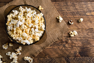 Air salty popcorn.A bowl of popcorn on a wooden table.Salt popcorn on the wooden background .  With space for text.Top view.popcorn texture.Chees .