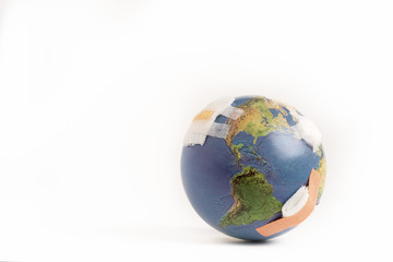 Closeup of a beautiful globe full of bandages as a symbolic of world environmental problem air pollution, waste disposal, fossil fuels which damaged earth and cause global warming. Isolated on white.