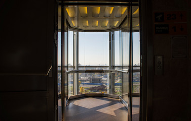 Transparent glass elevator with city view. © Payllik