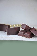 Dark Chocolate Bars on White Wooden with Pastel Green for Copy Space