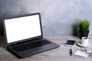 Fototapeta premium Laptop with blank screen for graphic display montage .Computer on wooden gray desk in office room. Mock up with plastic plant