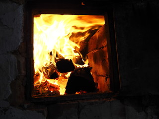 Obraz premium firewood burns in an old stove with a bright flame