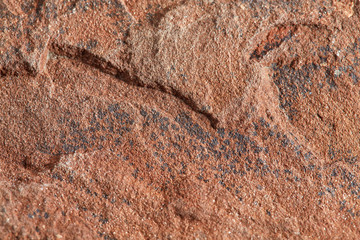 Grainy texture of reddish-orange natural stone. Natural backgrounds and textures. Construction and finishing. Top view.