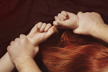Domestic violence abuse. Men's hands press the floor to the girl's hands.  man beats his wife....