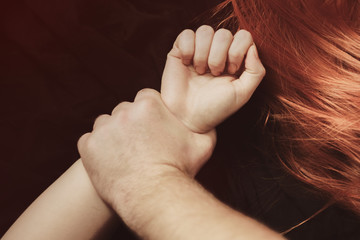 Domestic violence abuse. Men's hands press the floor to the girl's hands.  man beats his wife....
