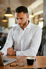 Obraz premium Young businessman using laptop in his office
