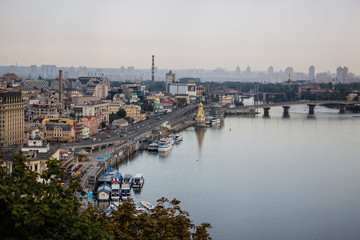Obraz premium Tour of Kiev in the center of Europe. View of the Dnieper, Trukhanov island and a foot bridge. Park fountain and sunset on the horizon..