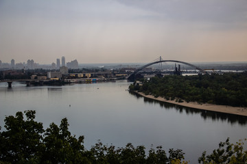 Obraz premium Tour of Kiev in the center of Europe. View of the Dnieper, Trukhanov island and a foot bridge. Park fountain and sunset on the horizon..