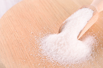 White cane sugar on a light wooden background
