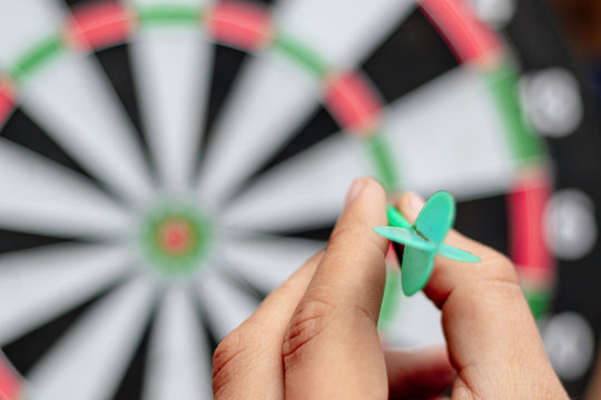 dart on hand before trowing to get win on dartboard target business and idea concept