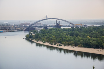 Tour of Kiev in the center of Europe. View of the Dnieper, Trukhanov island and a foot bridge. Park fountain and sunset on the horizon..