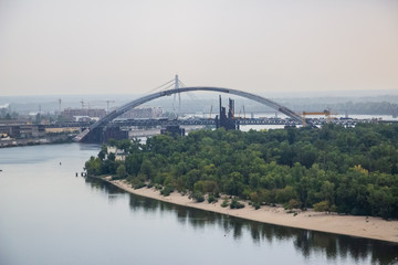 Tour of Kiev in the center of Europe. View of the Dnieper, Trukhanov island and a foot bridge. Park fountain and sunset on the horizon..