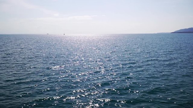 On the boat that is moving with Sunlight reflecting the sea surface.