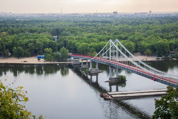 Tour of Kiev in the center of Europe. View of the Dnieper, Trukhanov island and a foot bridge. Park fountain and sunset on the horizon..
