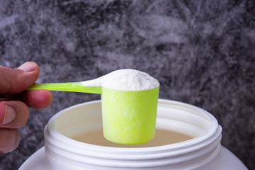 Sport nutrition supplement containers with shaker. Close up of protein powder and scoop