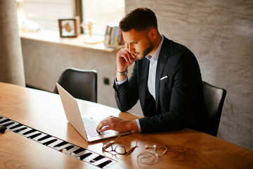 Young businessman using laptop in his office