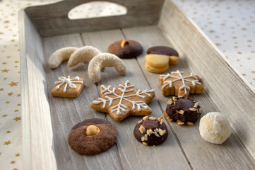 Group various kinds of delicious sweet Christmas cookies on light gray wood, tasty holiday breakfast