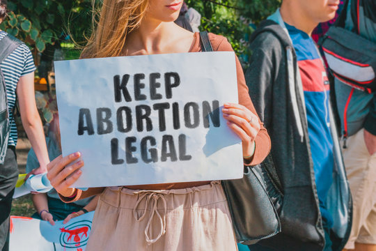 The phrase " Keep abortion legal " drawn on a paper in woman hands. Caucasian woman with light hair holds a cardboard with an inscription. Human Rights. Freedom. Choice