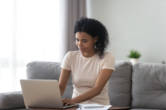 African American woman busy working on laptop from home