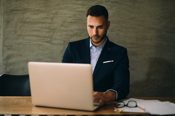 Young businessman using laptop in his office