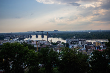 Tour of Kiev in the center of Europe. View of the Dnieper, Trukhanov island and a foot bridge. Park fountain and sunset on the horizon..
