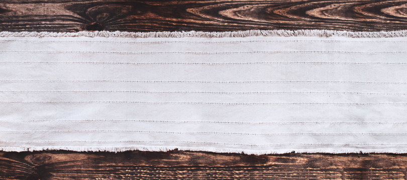 Grey fabric runner on an old wooden rustic table background with copy space. Top view.