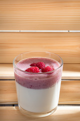 A cup of panna cotta with on wooden background Illuminated by sunlight. Selective focus. With copy space.