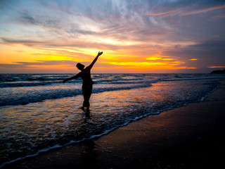 Black silhouettes of people against the sunset on the sea