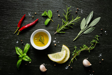 Selection of herbs and spices on black background, top view