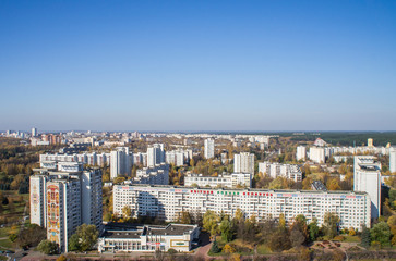 Fototapeta premium City architectural landscape Minsk. Office buildings of the road and parks. View from the roof with blue sky.