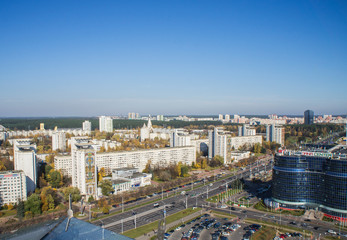 Fototapeta premium City architectural landscape Minsk. Office buildings of the road and parks. View from the roof with blue sky.