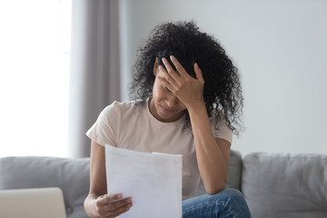 Upset black woman read bad news in correspondence letter