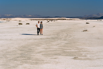 A loving couple walks along the coast of lake Salda in Turkey. Couple travels in Turkey. Lake Salda in Turkey. A lonely pair. Happy couple walking on empty sandy beach. Beautiful couple in nature