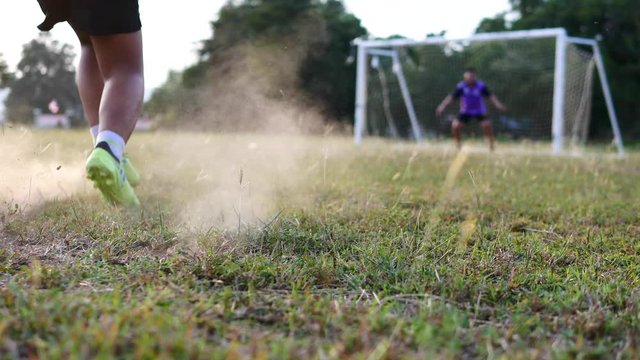 The Asian children are plying football in the glass field.	
